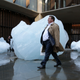 A man walks past a block of melting ice outside the Bloomberg building from an exhibit entitled ‘Ice Watch’ created by Icelandic-Danish artist artist Olafur Eliasson and leading Greenlandic geologist Minik Rosing.